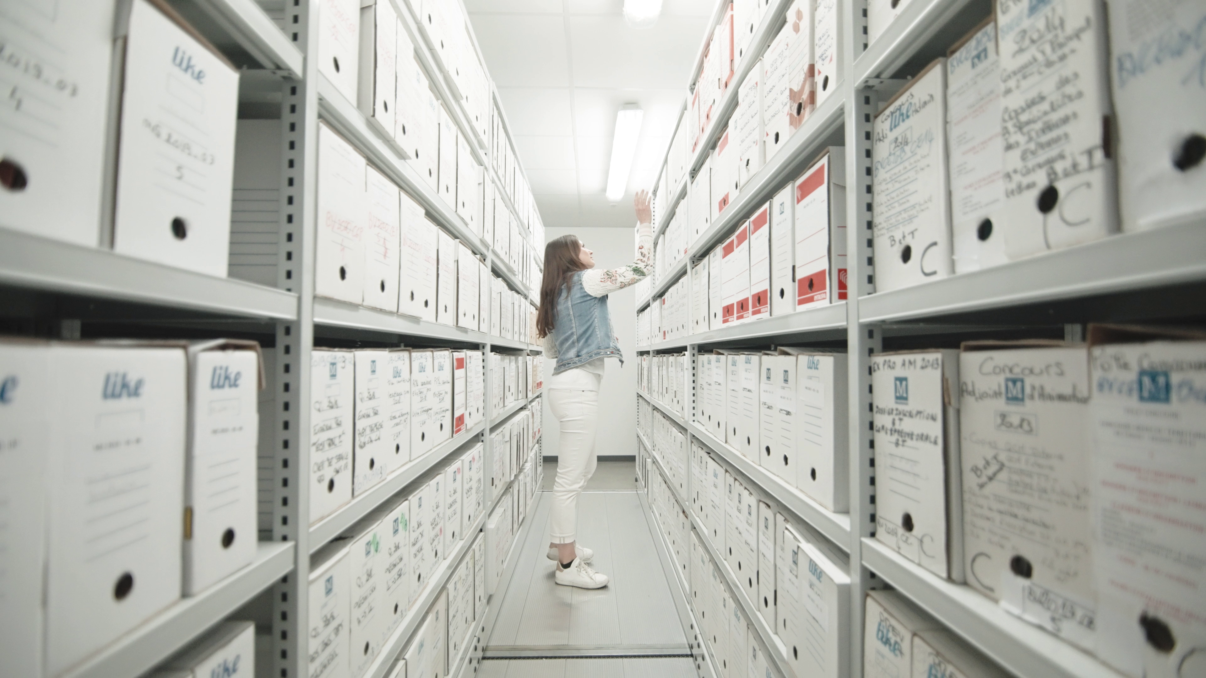 Une personne classe des archives au CDG83